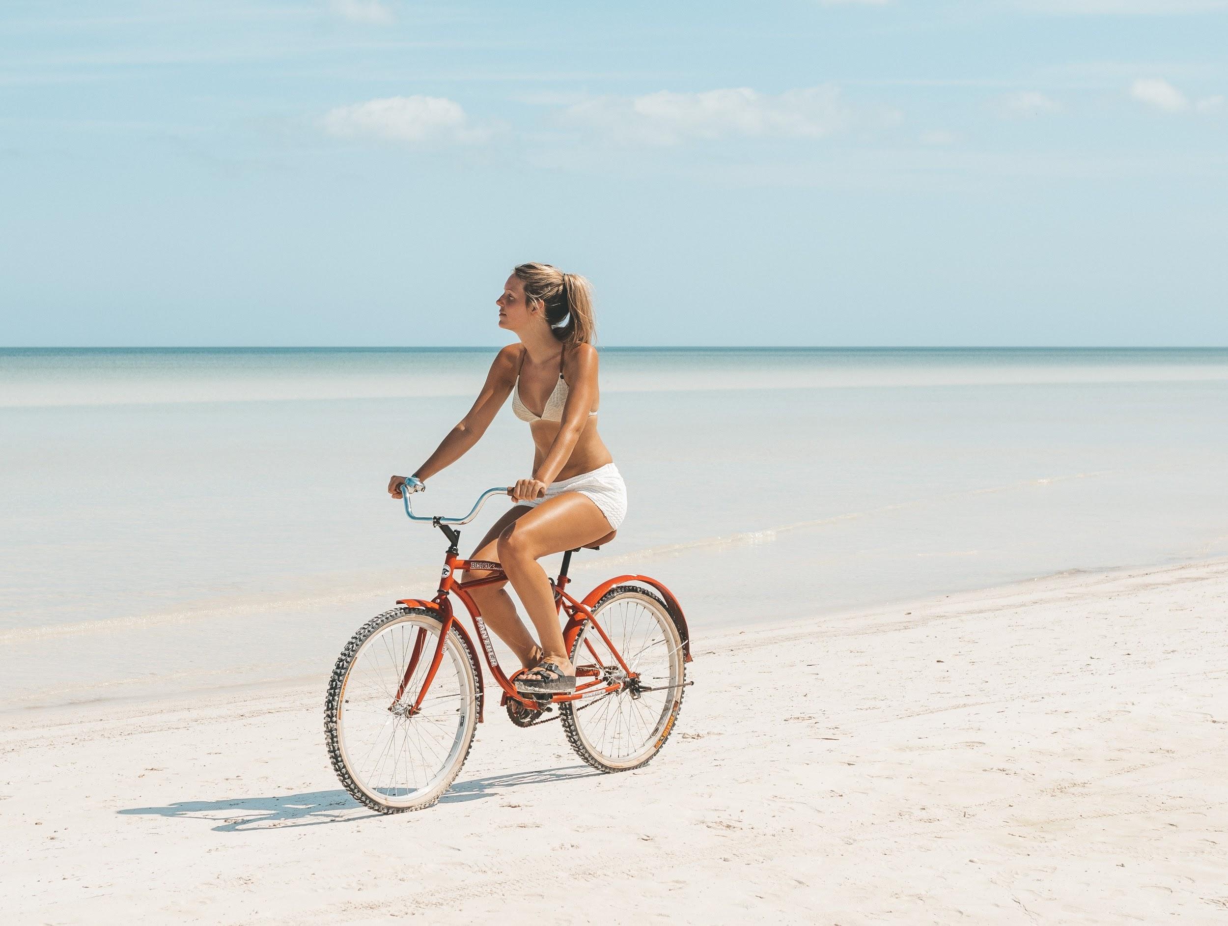 woman riding bike on secluded beach