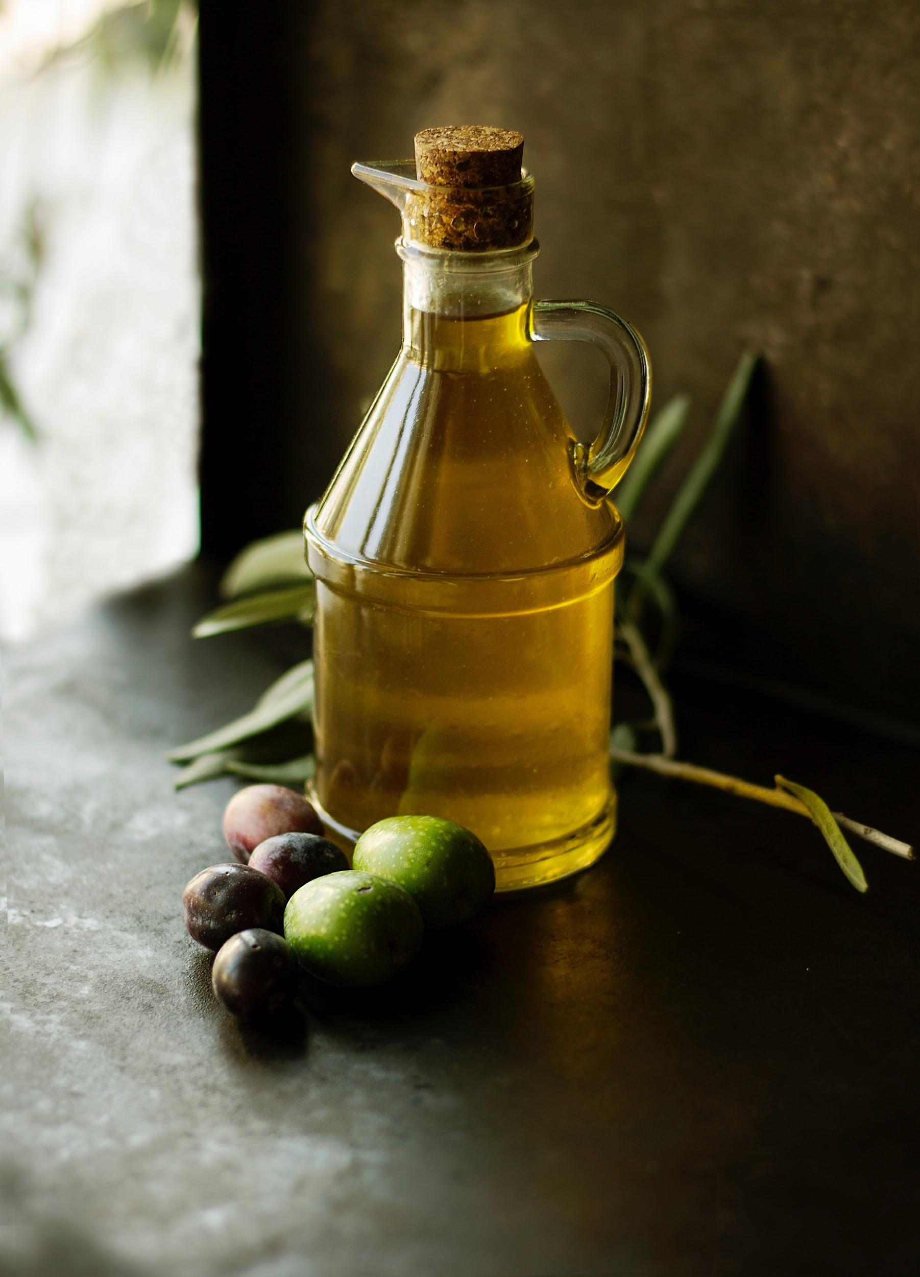 olive oil cruet with olives on table