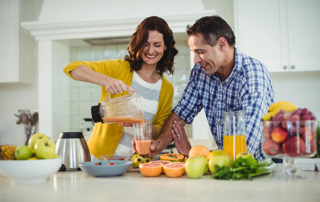 A couple adding selected fruit and fiber to their smoothie for preventing diabetes.